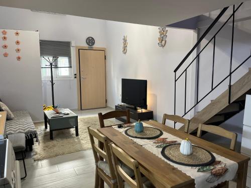 a living room with a dining table and a television at Chic & Cozy Apartment in Gazi, Athens in Athens