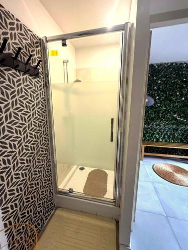 a shower with a glass door in a room at Casa Di Vibes - Jacuzzi - Sauna in Saint-Maur-des-Fossés
