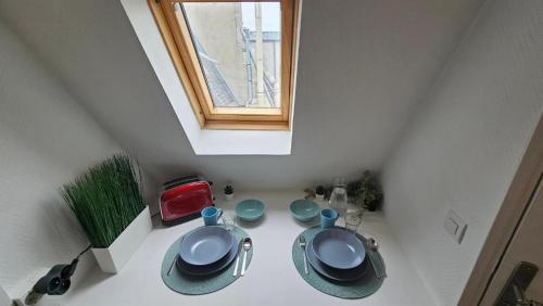 a room with a table with plates and a window at Appartement RENOVE EN PLEIN COEUR DE PARIS SUR L'ILE SAINT LOUIS ! in Paris
