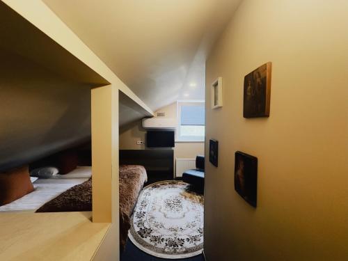 a small attic room with a bed and a chair at Very Bad Hootel in Kaunas