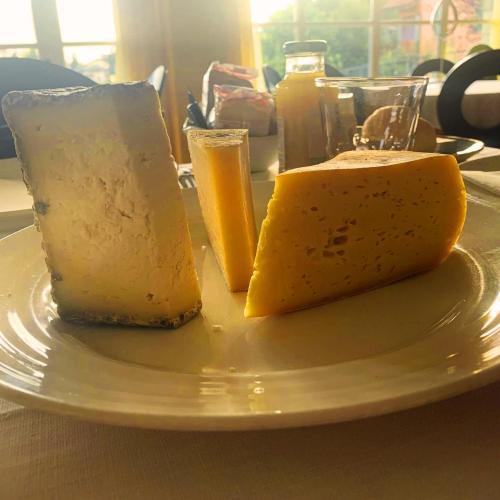 two pieces of cheese on a plate on a table at T'AMI Hotel Resort Spa in Selvino
