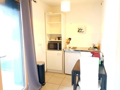 a kitchen with a sink and a microwave at Le Contemporain - Wifi - Proche centre ville in Lyon