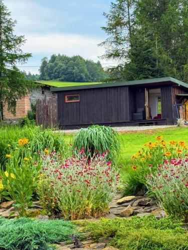 a garden with flowers in front of a building at Beautiful 1 bedroom village house among fields 