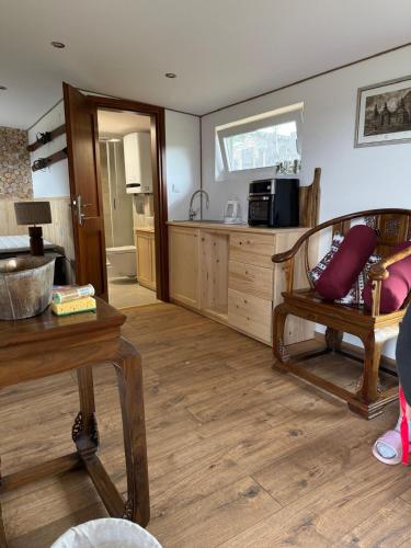 a living room with a table and a kitchen at Beautiful 1 bedroom village house among fields 