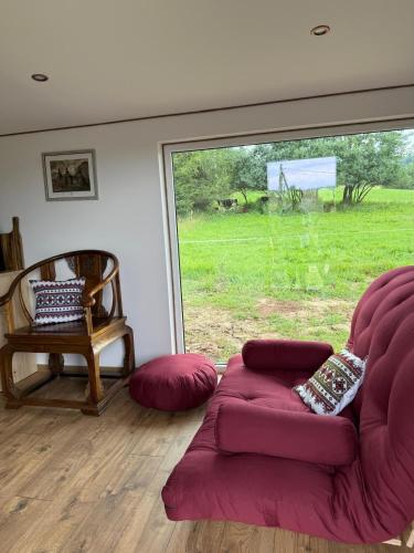 a living room with a couch and a large window at Beautiful 1 bedroom village house among fields 