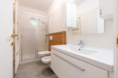 a white bathroom with a toilet and a sink at Casa Gigi in Vercana