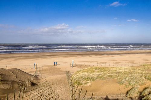 two people standing on a beach with the ocean at Les Murmures de la vigne in Avensan