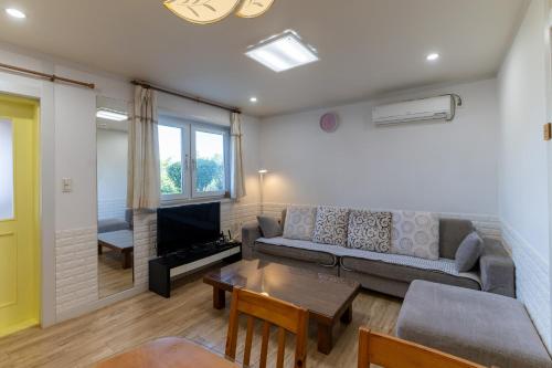 a living room with a couch and a table at Namhae Frankfurt Pension in Namhae