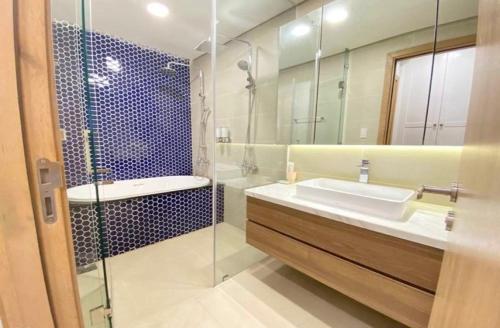 a bathroom with a sink and a glass shower at Căn hộ du lịch 2 phòng ngủ Aria Vũng Tàu Hotel & Villa Resort, Hồ bơi và bãi tắm riêng miễn phí, 30m ra biển in Vung Tau