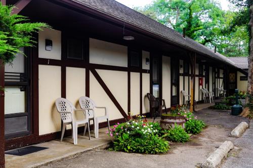 a group of chairs sitting outside of a building at The Earl of Sandwich Motel in East Sandwich