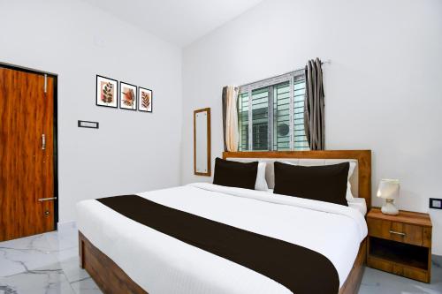 a bedroom with a large white bed and a window at Super Collection O VIP Road Near Golden Beach in Puri