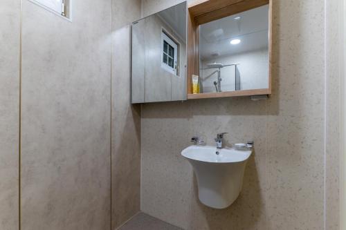 a bathroom with a sink and a mirror at Namhae Frankfurt Pension in Namhae