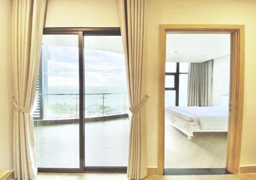 a bedroom with a view of a bed and a balcony at Căn hộ du lịch 2 phòng ngủ Aria Vũng Tàu Hotel & Villa Resort, Hồ bơi và bãi tắm riêng miễn phí, 30m ra biển in Vung Tau