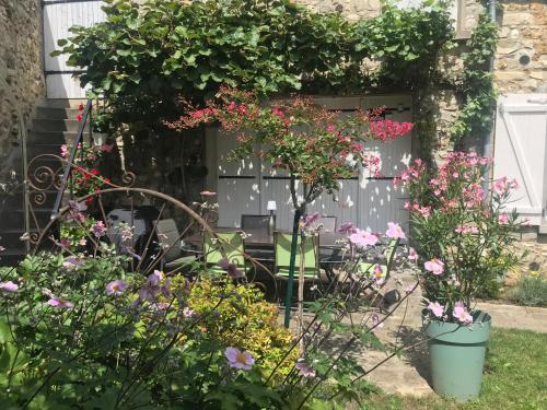 a garden with flowers in front of a garage at La Manounière in Mauchamps