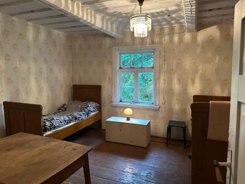 een slaapkamer met een bed, een tafel en een raam bij Retreat House in Lauvas