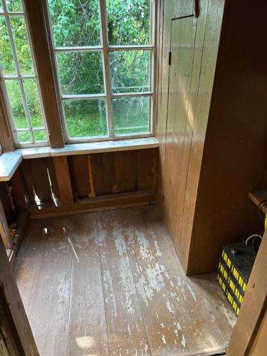 een lege kamer met een raam en een houten vloer bij Retreat House in Lauvas