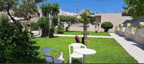 two white chairs and a table in a yard at Stacy's Studios in Kremasti