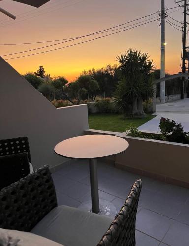 a table and chairs on a patio with a sunset at Stacy's Studios in Kremasti