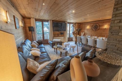a living room with a leather couch and a table at Chalet Magique - 4 stars - 4 bedrooms - center of Alpe d'Huez in LʼHuez