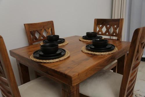 a wooden table with four black hats on it at The Empire Home in Entebbe