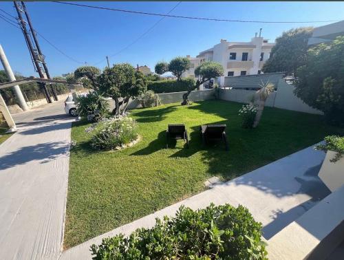 a backyard with a lawn with a table and benches at Stacy's Studios in Kremasti