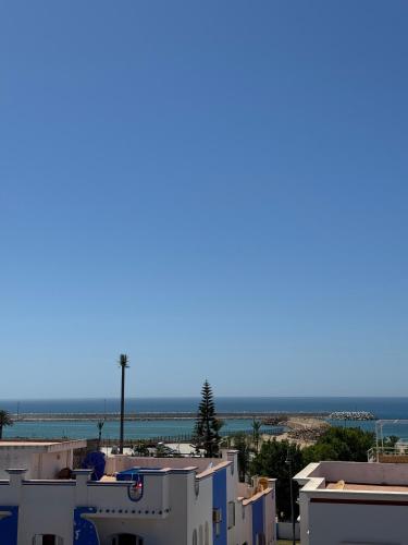 a view of the ocean from the roofs of houses at riad casa bahia asilah in Asilah