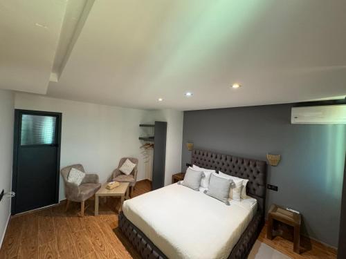 a bedroom with a white bed and a chair at riad casa bahia asilah in Asilah