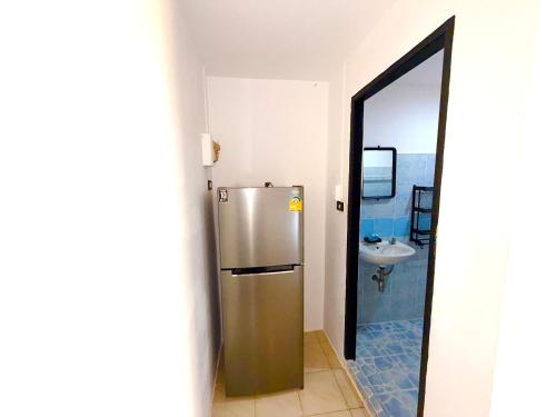 een roestvrijstalen koelkast in een badkamer met een spiegel bij Patong Canal Villa 305 in Patong Beach