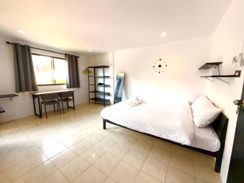 een slaapkamer met een bed en een tafel erin bij Patong Canal Villa 305 in Patong Beach