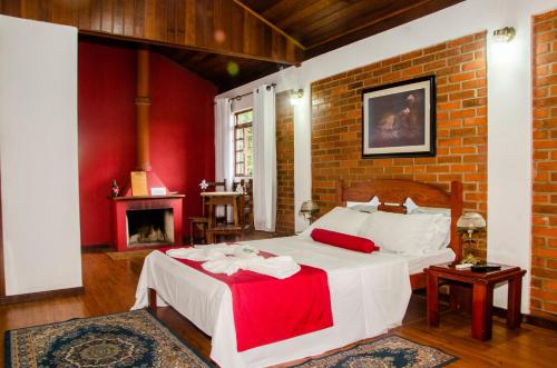 a bedroom with a bed and a brick wall at Pousada Aconchego Shangrilla in Penedo