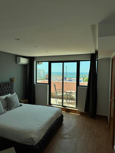 a bedroom with a bed and a view of the beach at riad casa bahia asilah in Asilah