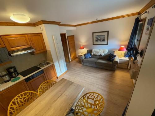 a living room with a couch and a table at Cozy studio 3 guests, private terrace, inside pool, spa, luxurious residence, ski-in ski-out in Bourg-Saint-Maurice
