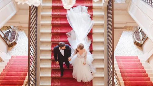 a bride and groom walking down the stairs at their wedding at San Clemente Palace Venice in Venice