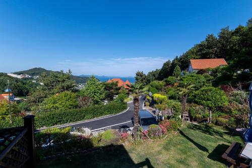a winding road with palm trees on a hill at Namhae Frankfurt Pension in Namhae