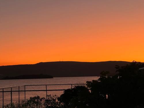 a sunset over a body of water at Brisa do Lago Pousada in Capitólio