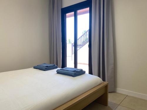 a bedroom with a bed with two blue towels on it at Pebble Beach in San Miguel de Abona