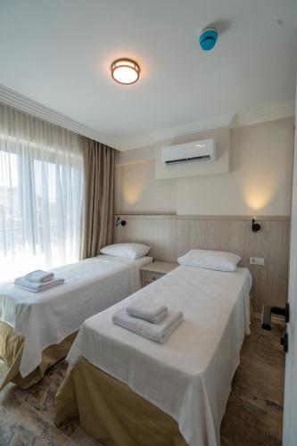 a hotel room with two beds with towels on them at Uliv Apart Hotel & SPA in Ayvalık