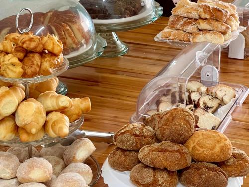 a table filled with different types of pastries and pies at Brisa do Lago Pousada in Capitólio