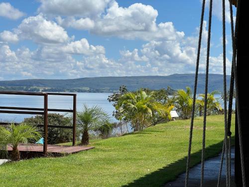 a view of the water from a swing at Brisa do Lago Pousada in Capitólio