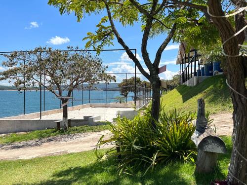 a park bench with a view of the water at Brisa do Lago Pousada in Capitólio