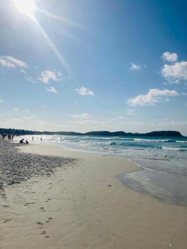 a beach with people and the ocean on a sunny day at Green Hotéis in Cabo Frio