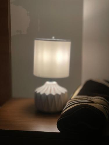 a lamp sitting on a table next to a bed at Appartement Mendoubia in Tangier