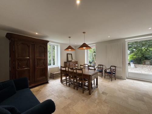 a dining room and living room with a table and chairs at Belle demeure de vacances in Meyronne