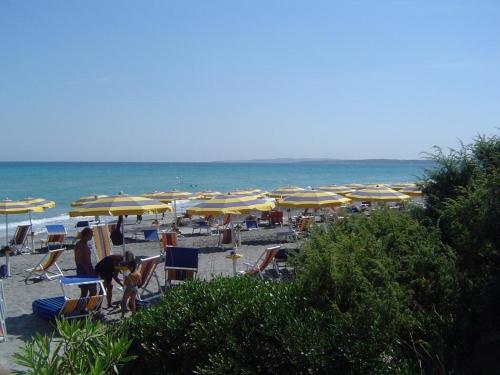 a bunch of chairs and umbrellas on a beach at ALIMINI 2 - Casa a 100 mt dal mare- House 100 meteres of the sea in Alimini