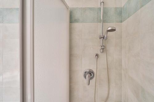 a shower with a shower head in a bathroom at Green Village Accommodations in Colico
