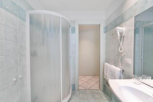 a bathroom with a shower and a sink and a tub at Green Village Accommodations in Colico