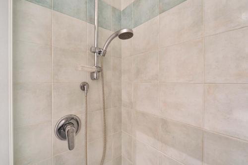 a shower with a shower head in a bathroom at Green Village Accommodations in Colico