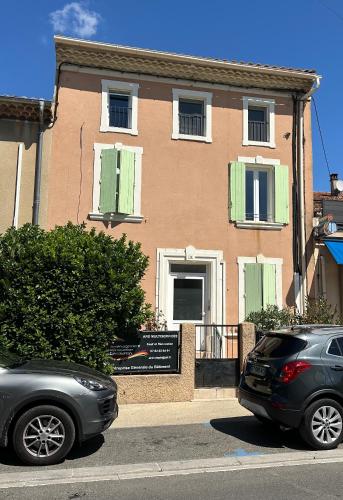 two cars parked in front of a building at Appartement centre ville camaret in Camaret-sur-Aigues