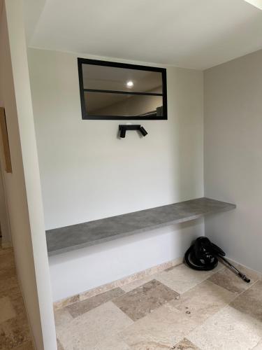 a tv on a wall with a shelf at Appartement centre ville camaret in Camaret-sur-Aigues