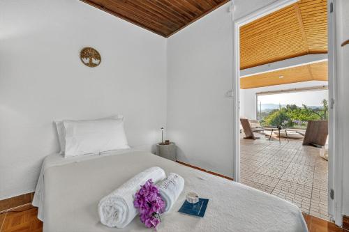 a bedroom with a white bed with purple flowers on it at Silent Place - Sintra in Paiõis